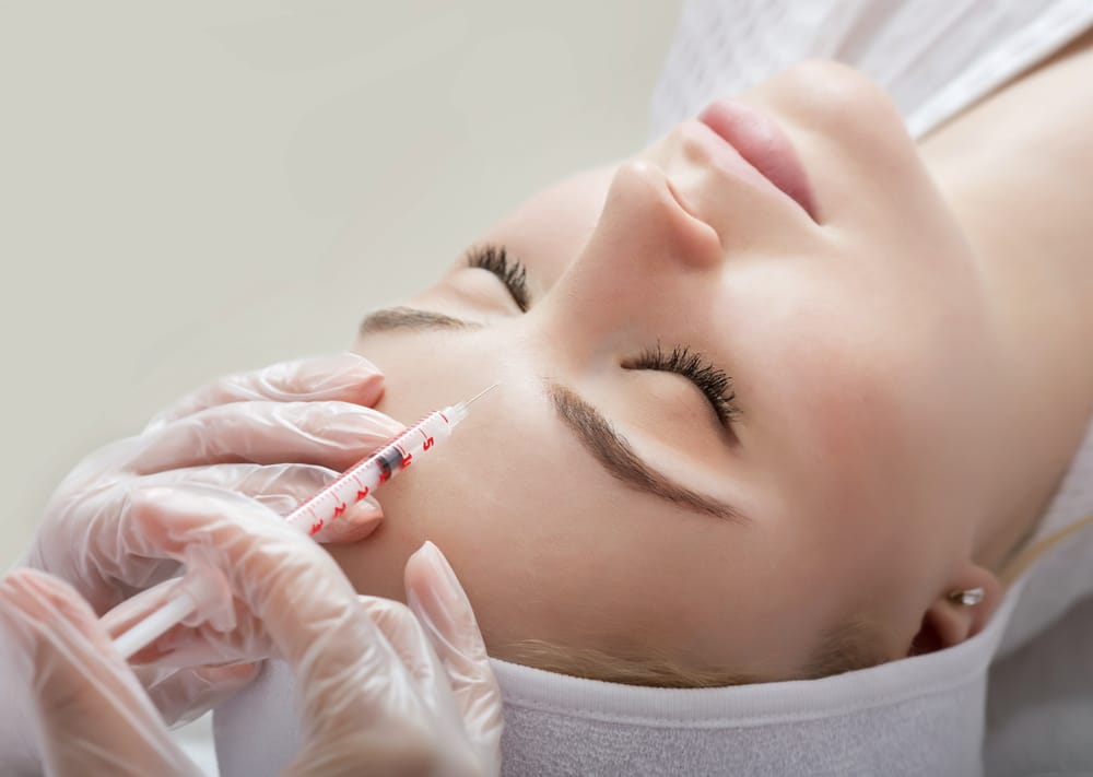 Hands,Of,Cosmetologist,Making,Injection,In,Face,,Lips.,Young,Woman